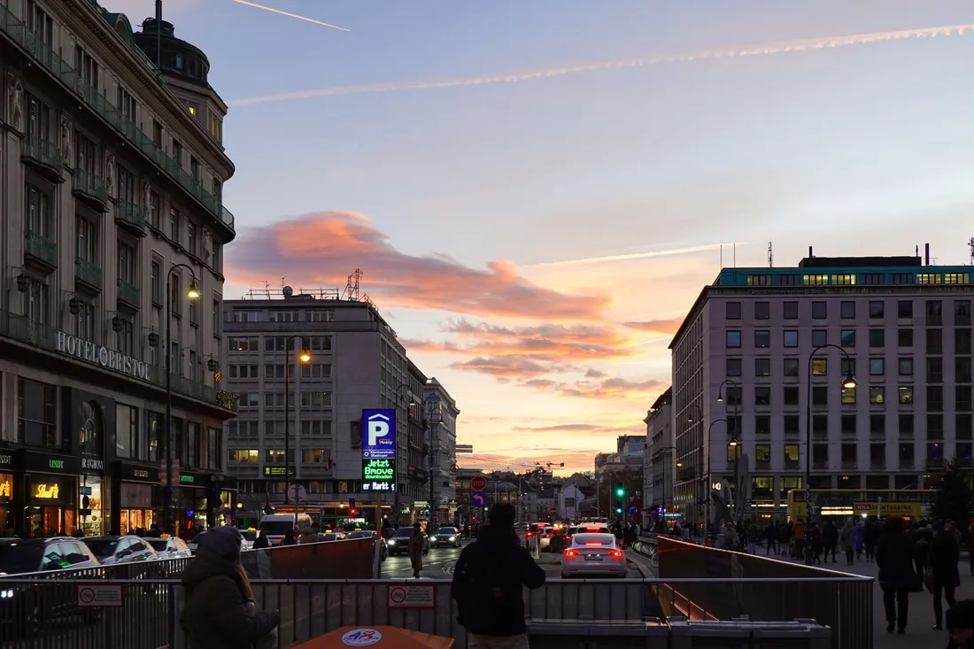 Straßenkreuzung in der Wiener Innenstadt bei Sonnenuntergang
