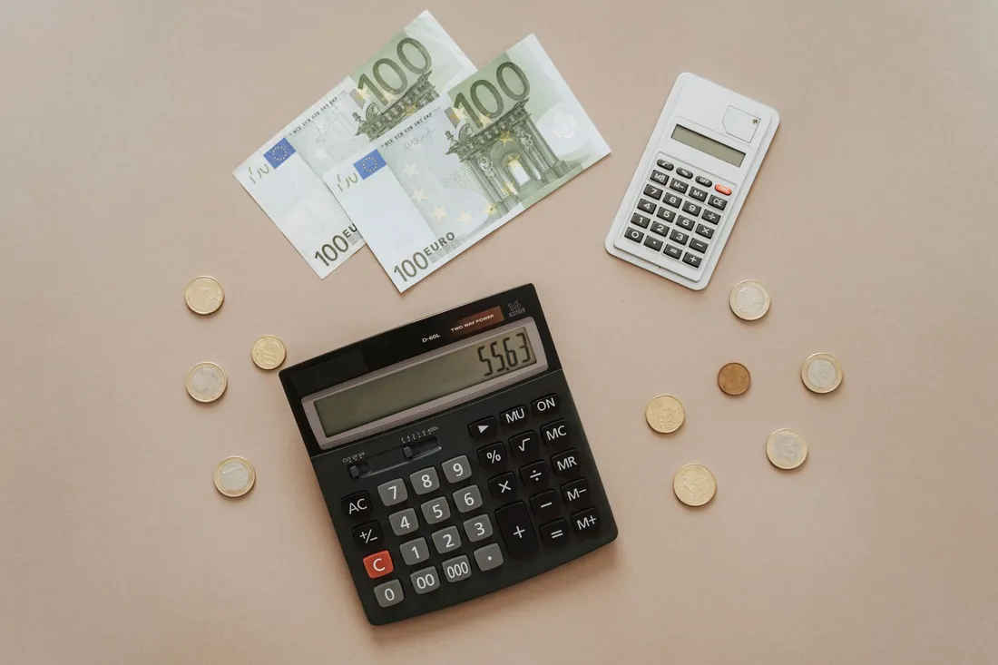 Taschenrechner, Euroscheine und Münzen für die Umzugskosten in der Steuererklärung